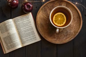 Buch und Tasse Tee mit Orangenscheibe