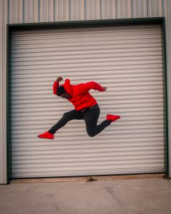 Mann in roter Kleidung springt in die Luft